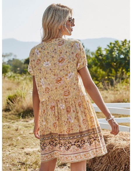 Kurzes gelbes Kleid mit geblümten Arabesken