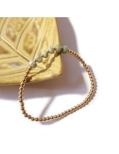 Elastic bracelet with faceted white jasper and small gold-tone beads