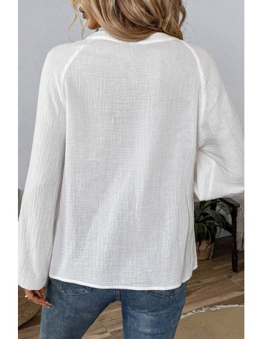 Weiße Bluse mit langen Ärmeln und blauer Boho-Stickerei